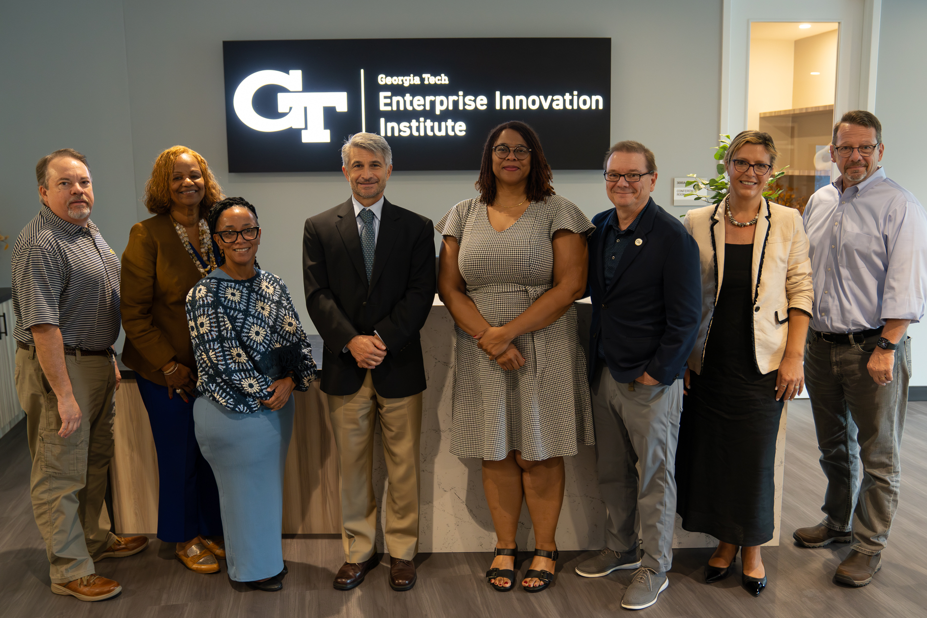 Two EDA representatives and six members of EI2's leadership group standing in front of a wall